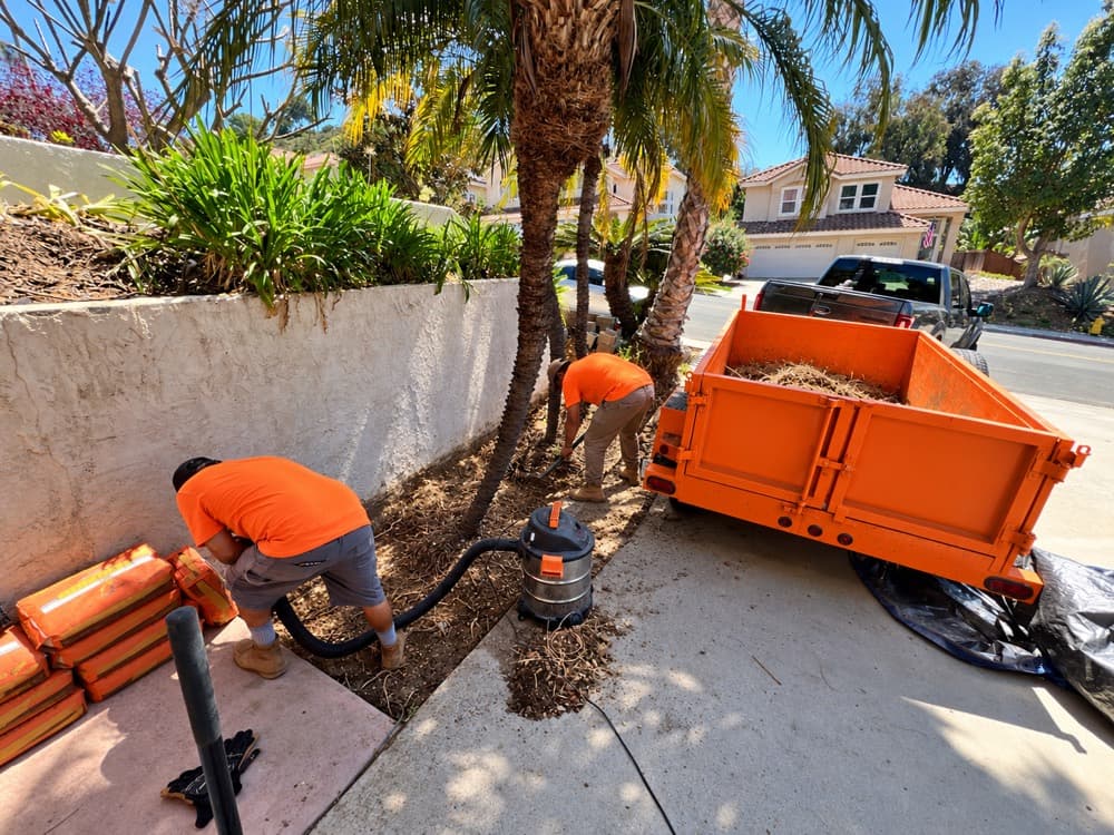 Crew clearing a planter bed into a dump trailer